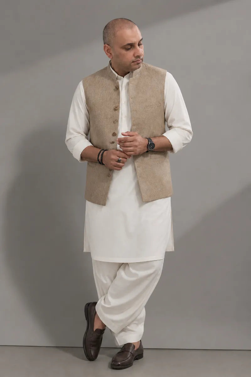 Atif in an ivory shalwar kameez and camel waistcoat, photographed in the studio